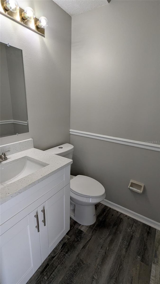 609 Whittingham Pl, Lake Mary, FL 32746 - half bathroom with wood finished floors, vanity, toilet, and a textured ceiling