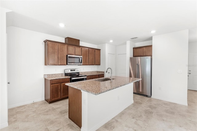 1396 Mirabella Cir, Davenport, FL 33897 - kitchen featuring appliances with stainless steel finishes, a sink, light stone counters, a kitchen island with sink, and baseboards