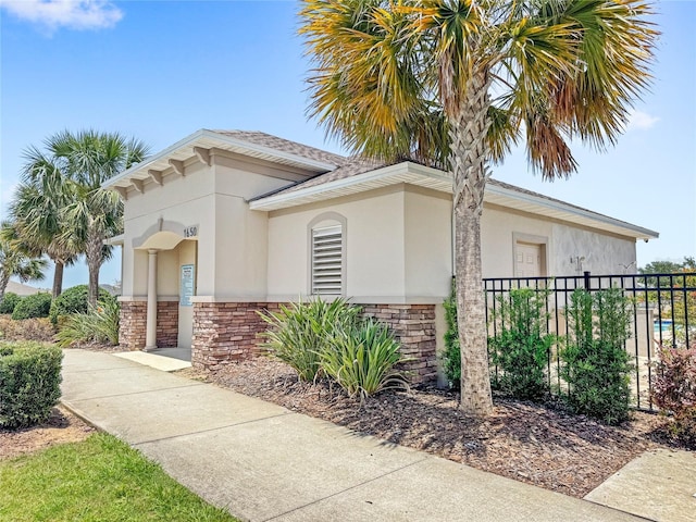1396 Mirabella Cir, Davenport, FL 33897 - view of home's exterior with stucco siding, fence, stone siding, and roof with shingles