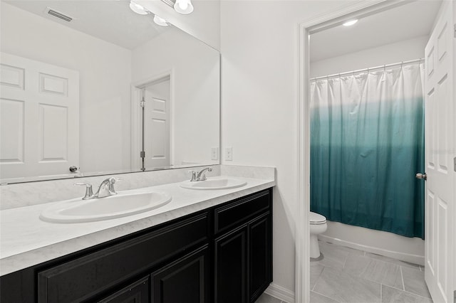 9356 St Therese St, Groveland, FL 34736 - bathroom with double vanity, toilet, and tile patterned floors