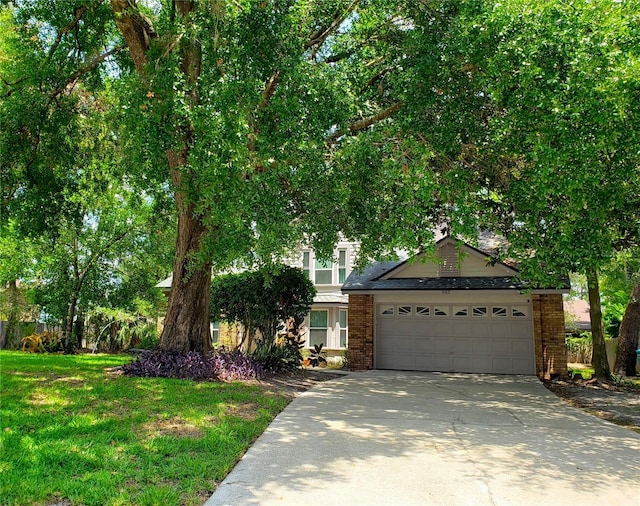 983 Bucksaw Pl, Longwood, FL 32750 - view of property hidden behind natural elements featuring driveway, a garage, brick siding, and a front yard