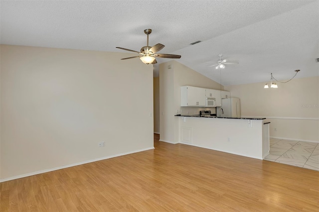 2714 Moncayo Ave, The Villages, FL 32162 - unfurnished living room featuring ceiling fan, vaulted ceiling, a textured ceiling, light wood-type flooring, and baseboards
