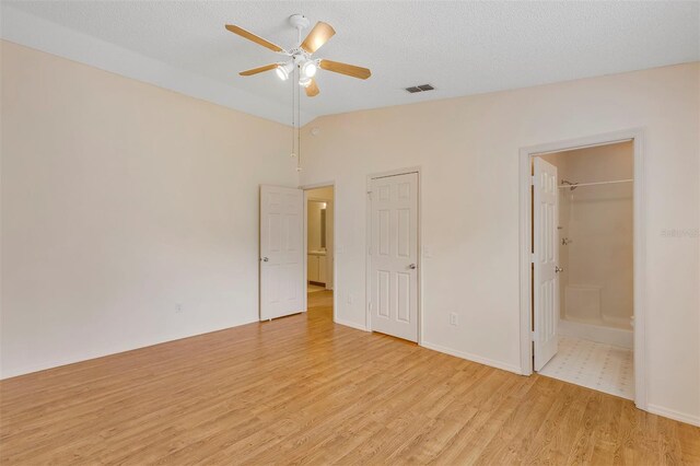 2714 Moncayo Ave, The Villages, FL 32162 - unfurnished bedroom featuring light wood finished floors, vaulted ceiling, ensuite bathroom, ceiling fan, and baseboards
