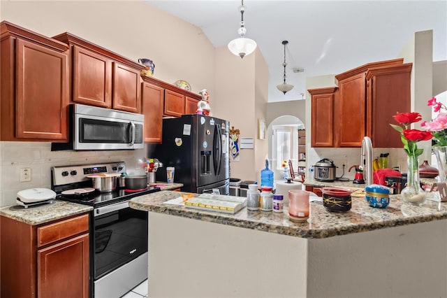 14 Sequoia Way, Kissimmee, FL 34758 - kitchen with stainless steel appliances, arched walkways, a peninsula, light stone countertops, and lofted ceiling