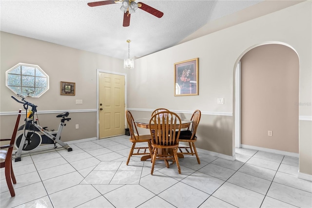 14 Sequoia Way, Kissimmee, FL 34758 - dining area with arched walkways, ceiling fan, a textured ceiling, light tile patterned floors, and baseboards