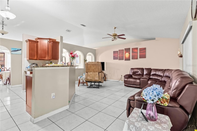 14 Sequoia Way, Kissimmee, FL 34758 - living room with vaulted ceiling, ceiling fan, light tile patterned flooring, arched walkways, and baseboards