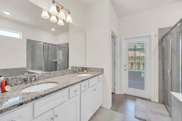 bathroom with a stall shower, plenty of natural light, and double vanity