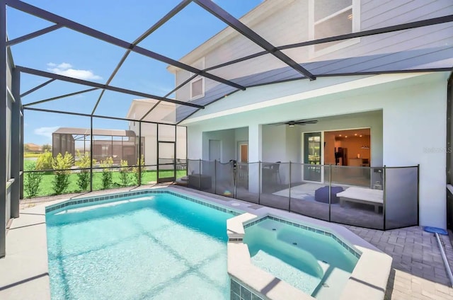 view of swimming pool featuring a patio, a pool with connected hot tub, ceiling fan, and glass enclosure