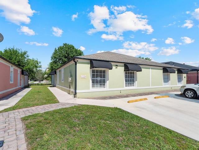 1064 Universal Rest Pl, Kissimmee, FL 34744 - view of front facade with a front yard, stucco siding, and uncovered parking