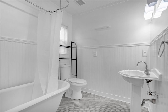 490 Shoreview Ave, Winter Park, FL 32789 - full bath featuring wainscoting, toilet, crown molding, and tile patterned flooring