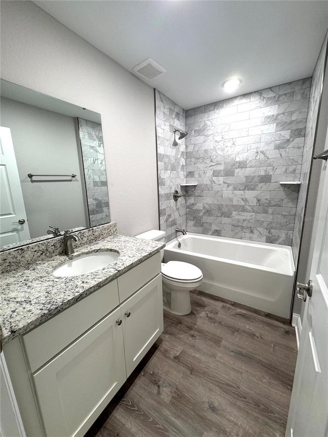 bathroom featuring tub / shower combination, wood finished floors, vanity, and toilet