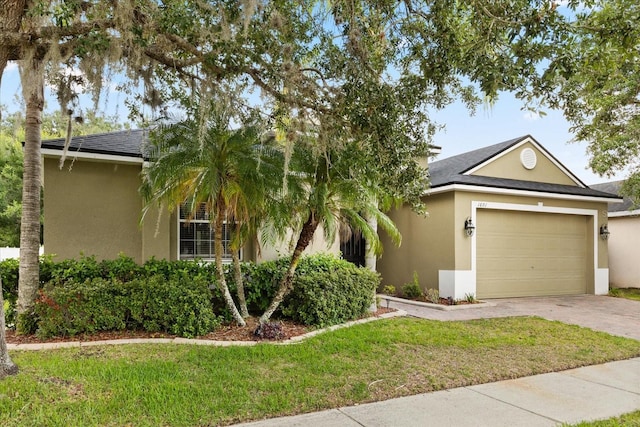 1601 Stargazer Ter, Sanford, FL 32771 - obstructed view of property with stucco siding, concrete driveway, a garage, a front yard, and roof with shingles
