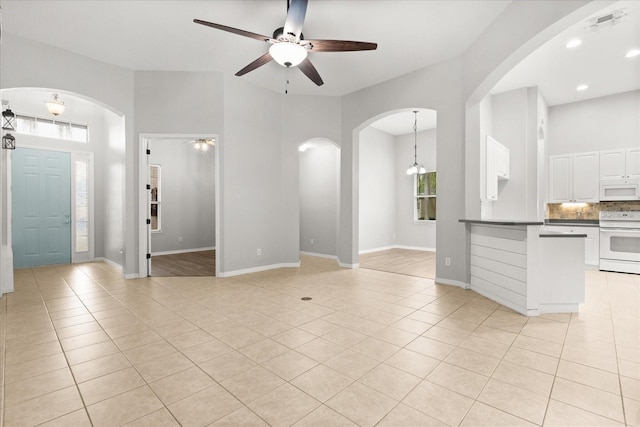 1601 Stargazer Ter, Sanford, FL 32771 - unfurnished living room featuring light tile patterned floors, arched walkways, ceiling fan, and baseboards