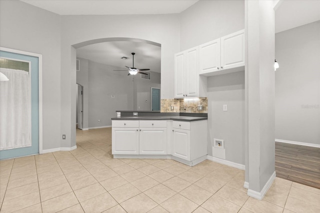1601 Stargazer Ter, Sanford, FL 32771 - kitchen featuring ceiling fan, dark countertops, light tile patterned floors, arched walkways, and white cabinets