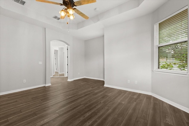 1601 Stargazer Ter, Sanford, FL 32771 - empty room with arched walkways, dark wood-style flooring, a ceiling fan, and a raised ceiling