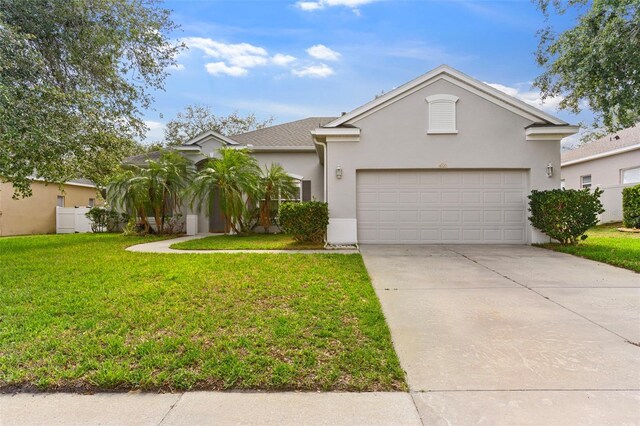 4520 Barrister Dr, Clermont, FL 34711 - view of front of property with a garage, a front lawn, driveway, and stucco siding