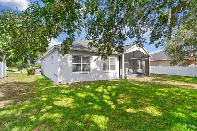4520 Barrister Dr, Clermont, FL 34711 - rear view of house with a sunroom, stucco siding, and a shingled roof