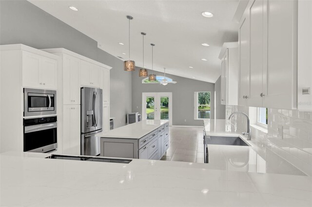 2776 Joseph Cir, Oviedo, FL 32765 - kitchen with appliances with stainless steel finishes, vaulted ceiling, french doors, backsplash, and a sink
