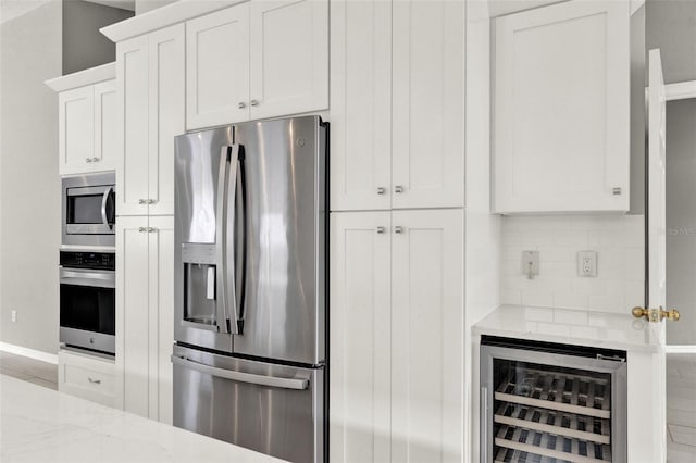 2776 Joseph Cir, Oviedo, FL 32765 - kitchen featuring appliances with stainless steel finishes, beverage cooler, light stone countertops, baseboards, and backsplash