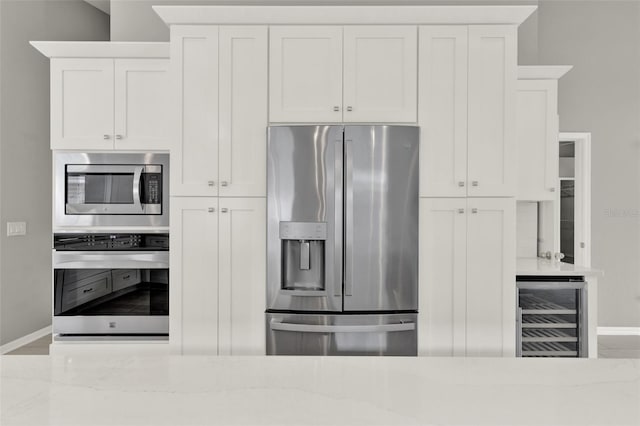 2776 Joseph Cir, Oviedo, FL 32765 - kitchen featuring stainless steel appliances, beverage cooler, baseboards, and light stone countertops