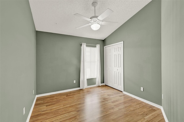 2776 Joseph Cir, Oviedo, FL 32765 - unfurnished bedroom featuring a textured ceiling, vaulted ceiling, light wood-style floors, a closet, and baseboards