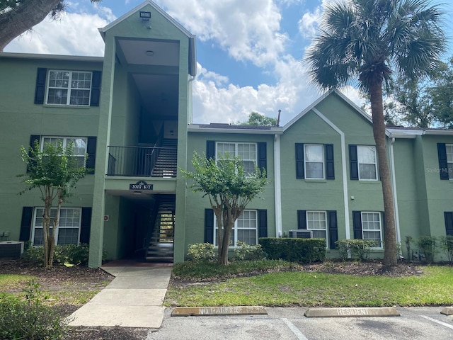 2007 Dixie Belle Dr Unit 2007M, Orlando, FL 32812 - view of property featuring stairway, uncovered parking, and cooling unit