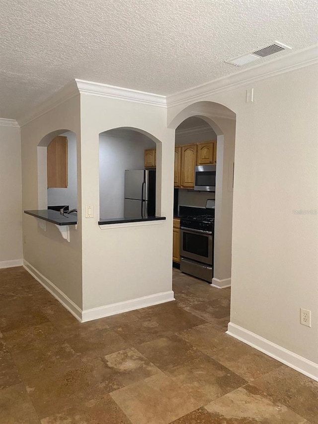 2007 Dixie Belle Dr Unit 2007M, Orlando, FL 32812 - kitchen featuring stainless steel appliances, ornamental molding, a textured ceiling, brown cabinetry, and baseboards