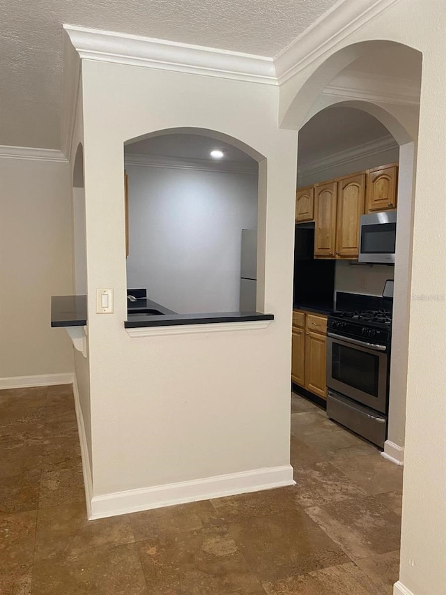 2007 Dixie Belle Dr Unit 2007M, Orlando, FL 32812 - kitchen featuring appliances with stainless steel finishes, crown molding, a textured ceiling, dark countertops, and baseboards