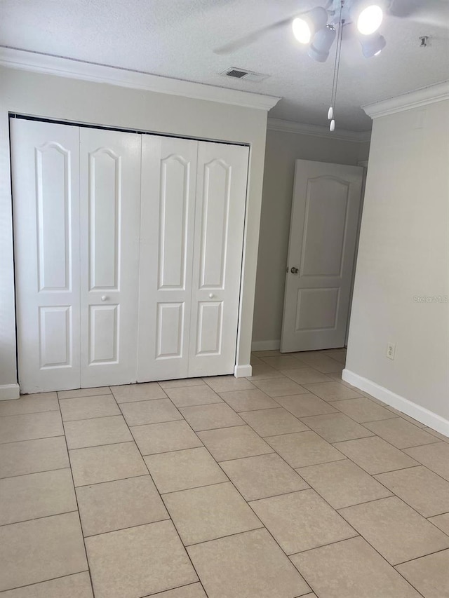 2007 Dixie Belle Dr Unit 2007M, Orlando, FL 32812 - unfurnished bedroom with a closet, baseboards, light tile patterned flooring, ornamental molding, and a ceiling fan