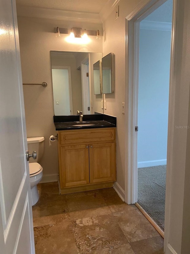 2007 Dixie Belle Dr Unit 2007M, Orlando, FL 32812 - half bath featuring ornamental molding, toilet, vanity, stone finish flooring, and baseboards