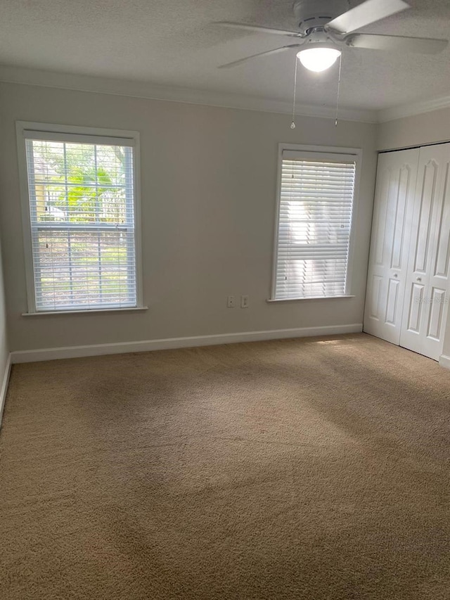 2007 Dixie Belle Dr Unit 2007M, Orlando, FL 32812 - unfurnished bedroom featuring ornamental molding, carpet, baseboards, a closet, and a ceiling fan