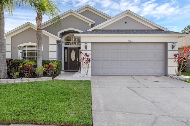 2520 Oakington St, Winter Garden, FL 34787 - ranch-style home featuring stucco siding, a garage, driveway, a front yard, and roof with shingles