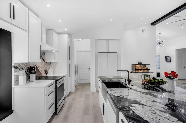 2520 Oakington St, Winter Garden, FL 34787 - kitchen featuring stainless steel range with electric cooktop, lofted ceiling, light stone countertops, white cabinetry, and backsplash