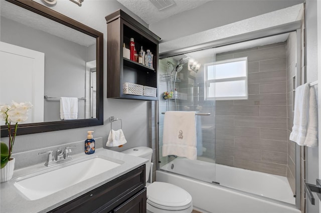 2520 Oakington St, Winter Garden, FL 34787 - bathroom featuring vanity, shower / bath combination with glass door, toilet, and a textured ceiling