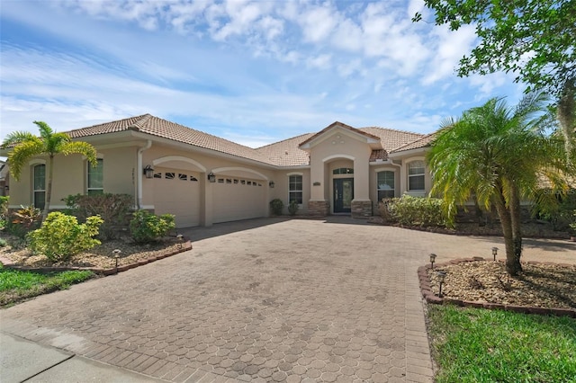 2801 Boat Cove Cir, Kissimmee, FL 34746 - mediterranean / spanish-style house with decorative driveway, a garage, stucco siding, and a tiled roof