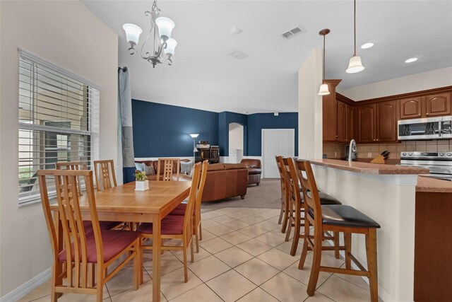 2801 Boat Cove Cir, Kissimmee, FL 34746 - dining room with a chandelier, light tile patterned floors, arched walkways, and baseboards