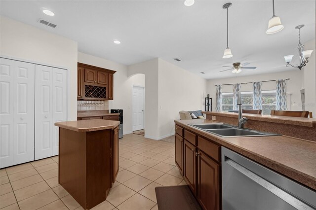 2801 Boat Cove Cir, Kissimmee, FL 34746 - kitchen with stainless steel dishwasher, arched walkways, ceiling fan, pendant lighting, and light tile patterned flooring
