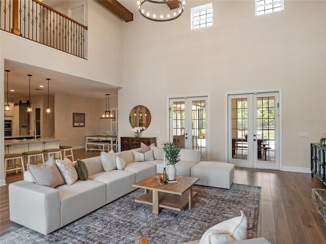 20199 Sweetwood Ln, Clermont, FL 34715 - living room featuring french doors, wood finished floors, a towering ceiling, a chandelier, and baseboards