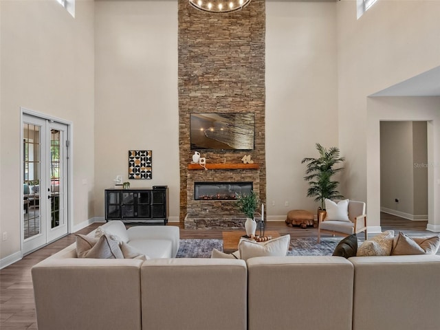 20199 Sweetwood Ln, Clermont, FL 34715 - living area featuring a towering ceiling, wood finished floors, healthy amount of natural light, baseboards, and a fireplace