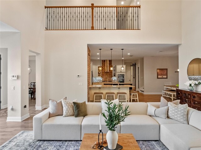 20199 Sweetwood Ln, Clermont, FL 34715 - living room featuring a high ceiling, light wood-type flooring, baseboards, and recessed lighting