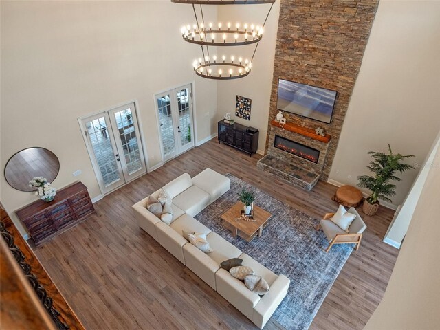 20199 Sweetwood Ln, Clermont, FL 34715 - living area with french doors, a chandelier, wood finished floors, a high ceiling, and baseboards