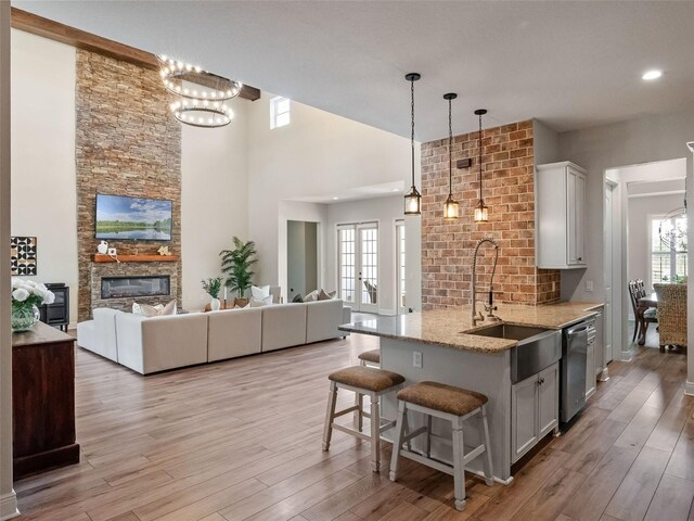 20199 Sweetwood Ln, Clermont, FL 34715 - kitchen with a sink, stainless steel dishwasher, light stone countertops, open floor plan, and a high ceiling