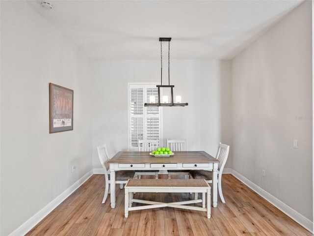 20199 Sweetwood Ln, Clermont, FL 34715 - dining room featuring a chandelier, light wood-type flooring, and baseboards
