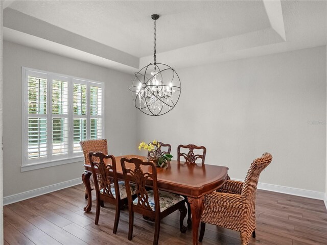 20199 Sweetwood Ln, Clermont, FL 34715 - dining area featuring baseboards, wood finished floors, a chandelier, and a raised ceiling
