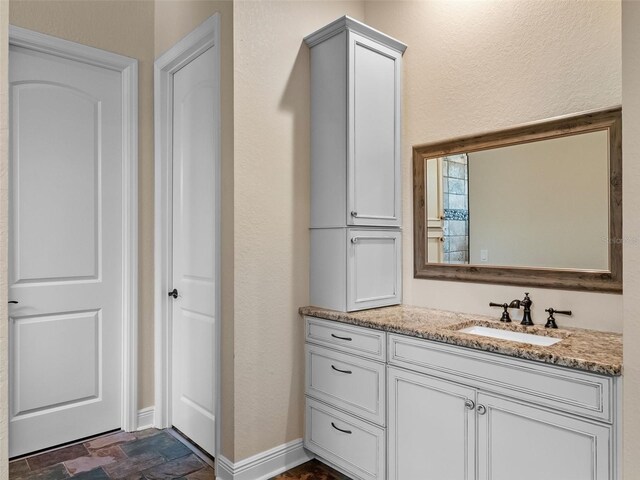 20199 Sweetwood Ln, Clermont, FL 34715 - bathroom featuring vanity, stone finish floors, and baseboards