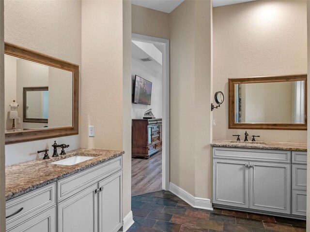 20199 Sweetwood Ln, Clermont, FL 34715 - full bathroom featuring baseboards, two vanities, and stone finish floors