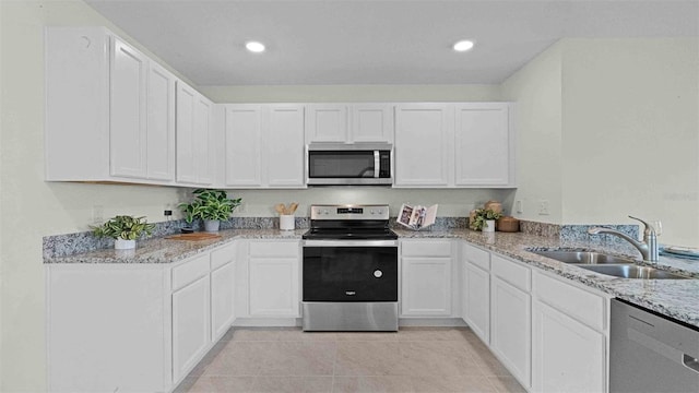 3665 Marlberry Way, Sanford, FL 32773 - kitchen with stainless steel appliances, a sink, light stone counters, white cabinets, and light tile patterned floors