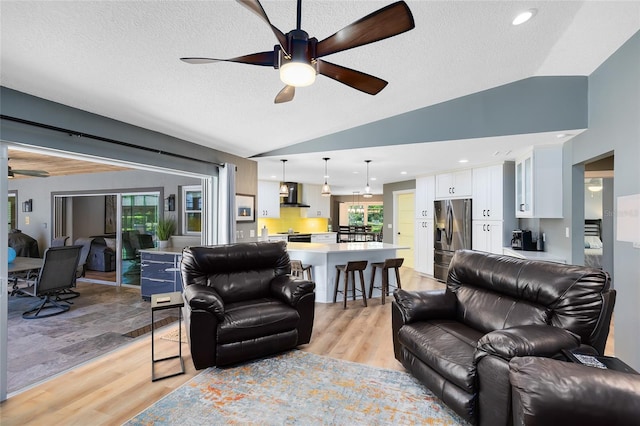 5370 Whispering Pine Cir, Saint Cloud, FL 34771 - living room with vaulted ceiling, a ceiling fan, light wood-type flooring, and a textured ceiling