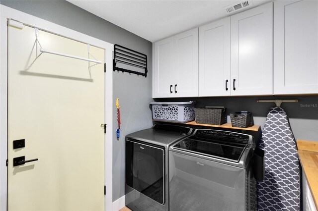 5370 Whispering Pine Cir, Saint Cloud, FL 34771 - laundry room featuring cabinet space and washer and clothes dryer