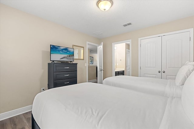 5353 Oakbourne Ave, Davenport, FL 33837 - bedroom featuring baseboards, dark wood-style flooring, a closet, and connected bathroom